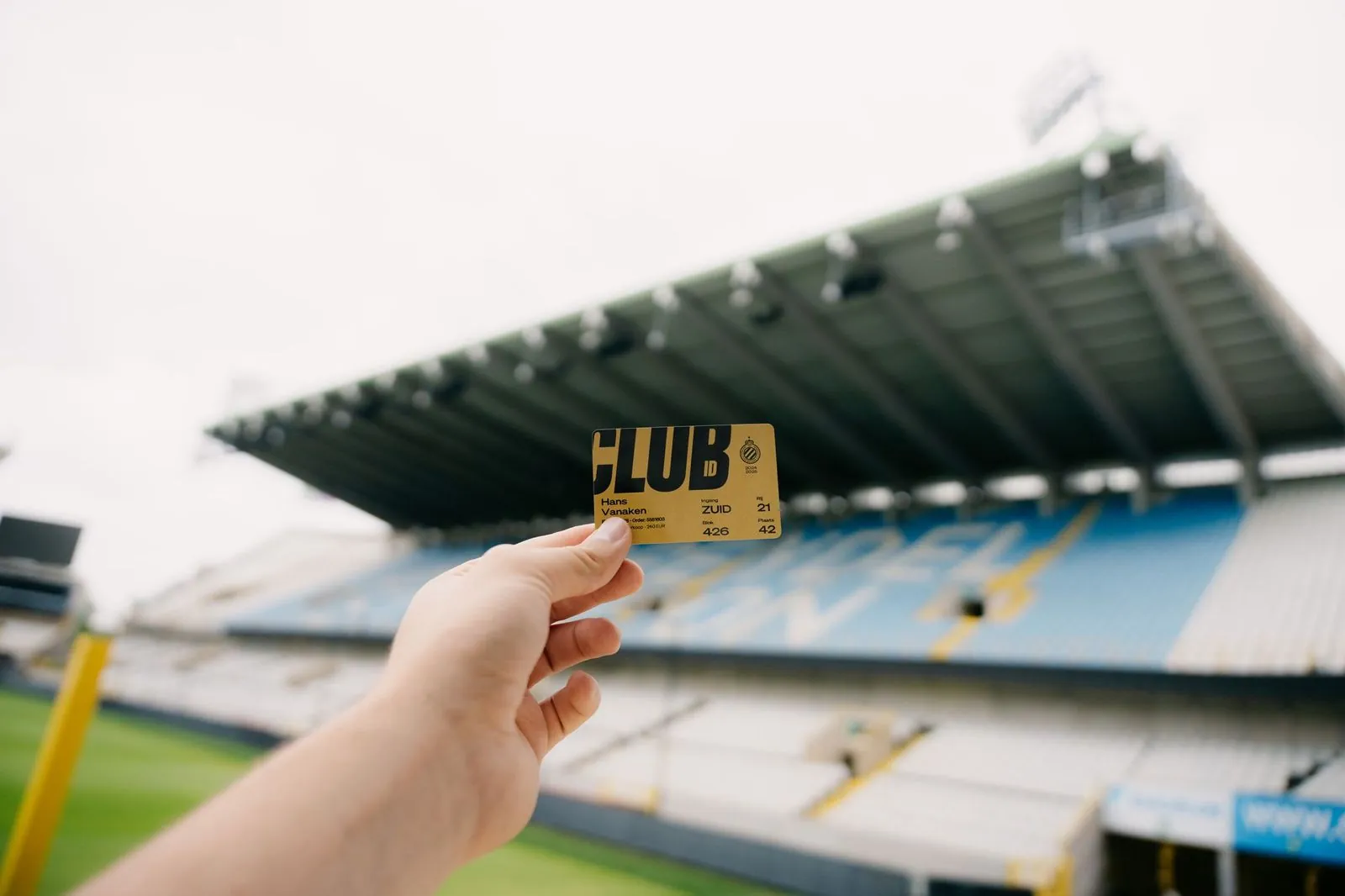 Een fan houdt een gouden Club ID-kaart omhoog in het stadion